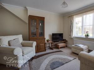 uma sala de estar com um sofá e uma televisão em Bridge Apartment em Weymouth