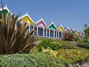 eine Reihe farbenfroher Häuser am Strand in der Unterkunft Harbour View Bungalow in Weymouth
