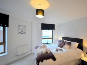 a white bedroom with a large bed with pillows at Old Harbour View in Weymouth