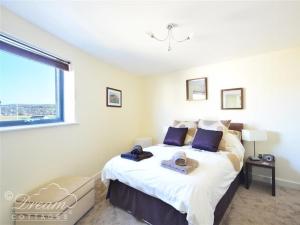 a bedroom with a large bed with a window at The Boardwalk in West Bay