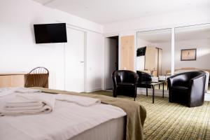 a hotel room with a bed and two chairs at Vila Turistica Casa Gabriela in Bucharest