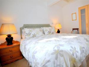 a bedroom with a bed and two lamps on a night stand at Fountain Cottage in Weymouth