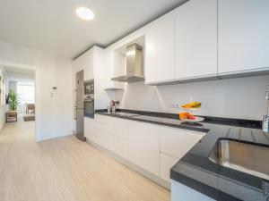 a kitchen with white cabinets and black counter tops at MALAGUETA SEA VIEW - PREMIUM APARTMENT in Málaga