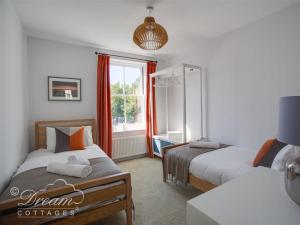 ウェイマスにあるMarina Vistaのベッド2台と窓のある寝室