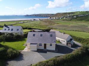 eine Luftaufnahme eines Hauses und des Ozeans in der Unterkunft Bramble Cottage in Haverfordwest