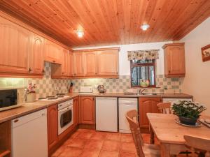 a kitchen with wooden cabinets and a wooden table at Shires Rest in Buxton