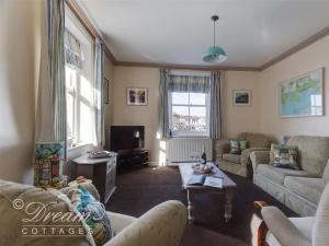 a living room with two couches and a tv at Buccaneer Cottage in Weymouth