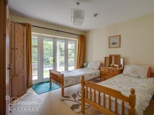 ein Schlafzimmer mit zwei Betten und einem Fenster in der Unterkunft Harbour View Bungalow in Weymouth