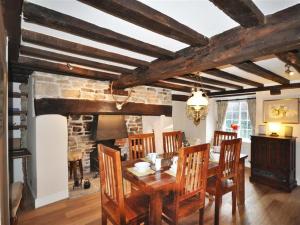 a dining room with a table and a stone fireplace at Ivy Cottage in West Lulworth