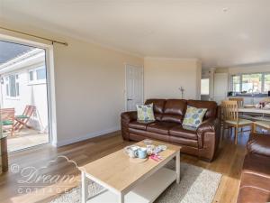 a living room with a leather couch and a table at Seacliff in West Bay