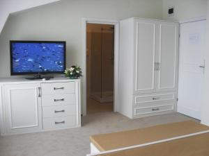 a living room with a flat screen tv on a white cabinet at City Hotel Bucharest in Bucharest