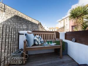 a wooden bench sitting on top of a balcony at Ammonite Cottage in Portland