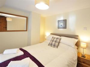 1 dormitorio con 1 cama blanca grande y espejo en Little Ivy en West Lulworth