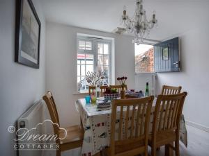 ein Esszimmer mit einem Tisch mit Stühlen und einem Kronleuchter in der Unterkunft Ocean Swell in Weymouth