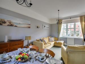 ein Wohnzimmer mit einem Tisch mit einer Obstschale darauf in der Unterkunft Rupert Cottage in Weymouth