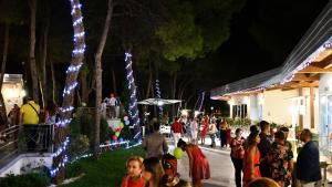 Eine Menschenmenge, die vor einem Gebäude mit Lichtern steht. in der Unterkunft Sira Resort in Nova Siri Marina