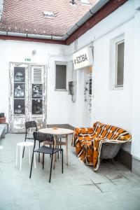 a patio with a table and chairs and a tub at a SZOBA apartman in Pécs