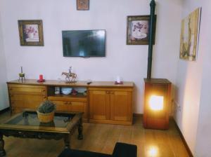 a living room with a tv and a table at Casa Rivera Río Jucar in Valdeganga