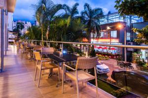 a balcony with tables and chairs on a building at Hotel Dann Carlton Bucaramanga in Bucaramanga