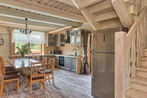 a kitchen with a table and a stainless steel refrigerator at Rezydencja Limajno in Dobre Miasto