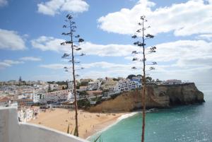 Blick auf einen Strand mit Gebäuden und Bäumen in der Unterkunft Casa Franki - Stylish and large beach apartment in Algarve in Carvoeiro