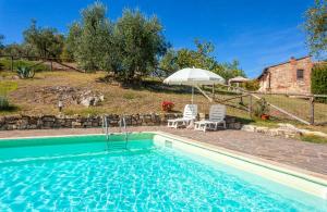 a swimming pool with two chairs and an umbrella at Agriturismo I Ceppi in San Casciano in Val di Pesa