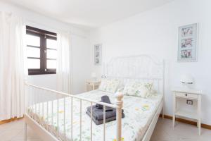 ein weißes Schlafzimmer mit einem Bett und einem Fenster in der Unterkunft Luxury Apartment in Costa Adeje in Adeje + 19 Fotos