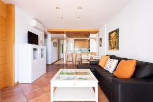 ein Wohnzimmer mit einer schwarzen Couch und einem Tisch in der Unterkunft Luxury Apartment in Costa Adeje in Adeje