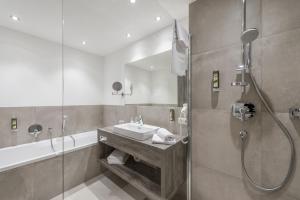 ein Bad mit einem Waschbecken und einer Dusche in der Unterkunft Hotel Burgstein - alpin & lifestyle in Längenfeld