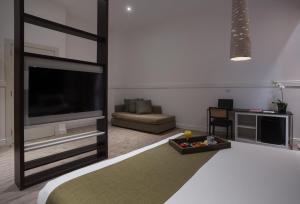 a living room with a tv and a bed at Esplendor by Wyndham Savoy Rosario in Rosario