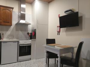 a kitchen with a small table and a refrigerator at Mar de Prata in Maia