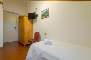 a room with a bed and a suitcase on the floor at Hotel Alle Vecchie Arcate in Pescasseroli