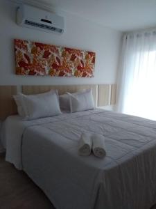 een slaapkamer met een groot wit bed en handdoeken bij Mont Ararat Alto da Pitinga in Porto Seguro