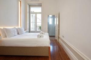 a bedroom with a bed with two teddy bears on it at Downtown Colosseum Apartments in Porto