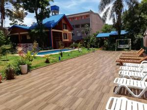 伊瓜蘇港的住宿－Hotel Amayal，一个带白色椅子的甲板和游泳池