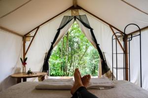 - une personne dormant sur un lit dans une tente dans l'établissement Cascada Elysiana, à Platanillo