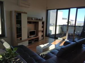 un soggiorno con divano blu e TV di Apartment Morski cvet a Capodistria