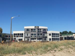 un gran edificio blanco con una luz de la calle delante de él en Waterfront Apartments Whitianga en Whitianga