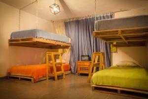 a bedroom with two beds and two stools at Bababuy Hostel in Bogotá