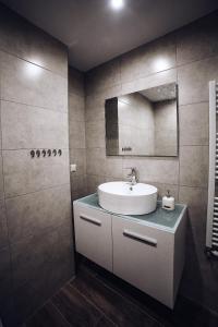 a bathroom with a sink and a mirror at Seaview Deluxe Apartments Thessaloniki in Thessaloniki