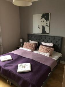 a bedroom with a purple bed with two towels on it at Glamour Residence in Warsaw