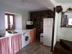 a kitchen with a white refrigerator and a washing machine at Casa Gelina in Corras de la Puente