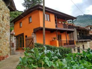 une maison orange avec des plantes devant elle dans l'établissement Casa Gelina, à Corras de la Puente