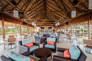 un restaurant avec des chaises et des tables et un grand plafond dans l'établissement Margaritaville Beach Resort Playa Flamingo, à Playa Flamingo