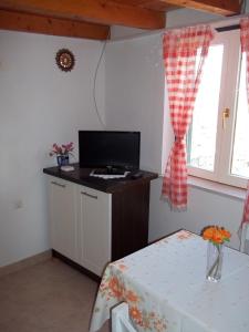 a room with a table with a television on a counter at Holiday Home Ruža in Mirce +18 photos