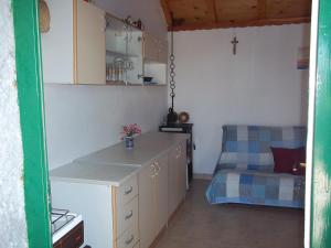 a kitchen with a table and a bed in a room at Holiday Home Ruža in Mirce