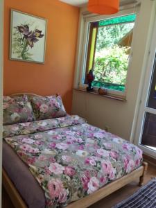 a bedroom with a bed with flowers on it at Forest house with outdoor hot tub in Jūrmala