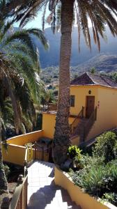 AlojeraにあるLa Pimenteraのヤシの木が目の前に広がる黄色い家