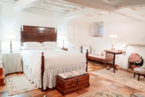 オビドスにあるCasa de Cima - Muralha do Castelo de Óbidosのベッドルーム1室(大型ベッド1台、木製ヘッドボード付)