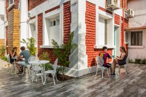 un groupe de personnes assises à des tables sur un patio dans l'établissement Hostal Casa Aborigen, à Santiago